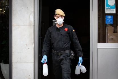 Un militar de la UME sale con botellas de plástico de la residencia geriátrica Marvi Park Mallorca, en Barcelona.