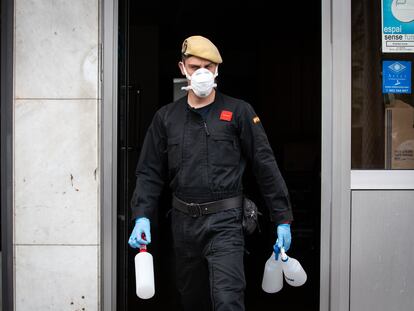 Un militar de la UME sale con botellas de plástico de la residencia geriátrica Marvi Park Mallorca, en Barcelona.