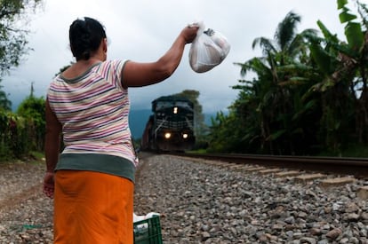 Cuando oyen los pitidos del tren, rápidamente las mujeres se despliegan en unas decenas de metros como pueden y alargan los brazos con las bolsas sujetos suavemente con los dedos a modo de pinza, como hace doña Julia.