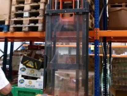 Un voluntario coloca cajas vacías en el almacén del Banco de Alimentos.
