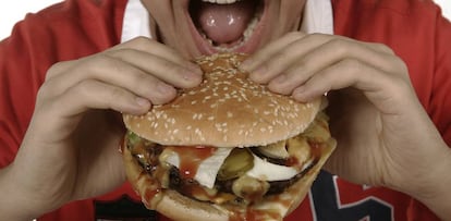 Un hombre come una hamburguesa.
