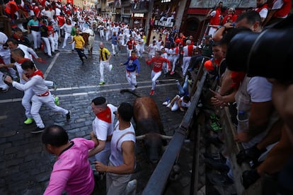 Corredores y astados en la curva de Mercaderes en el segundo encierro de los Sanfermines.