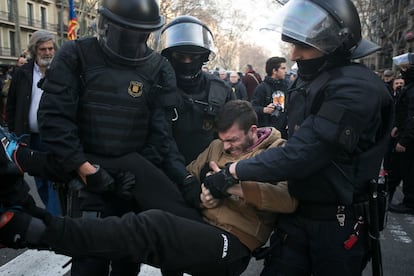 Algunas de las principales plantas industriales de Cataluña, como la de Seat en Martorell (Barcelona) o la planta de Nissan en la Zona Franca funcionan con normalidad pese a la huelga. En la imagen, agentes de los Mossos d'Esquadra retiran a un manifestante de la Gran Vía de Barcelona.