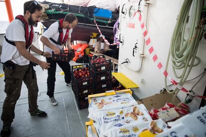 Trabajadores de MSF colocan los suministros recibidos por otra embarcación italiana en la cubierta del 'Aquarius', el 12 de junio de 2018.