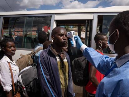 Un sanitario toma la temperatura en una estación de autobuses en Kigali (Ruanda). 
