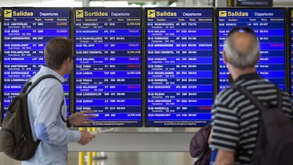 Dos viajeros consultan las cancelaciones ayer en el aeropuerto de El Prat.