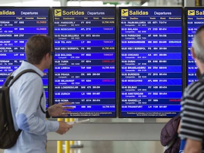 Dos viajeros consultan las cancelaciones ayer en el aeropuerto de El Prat.