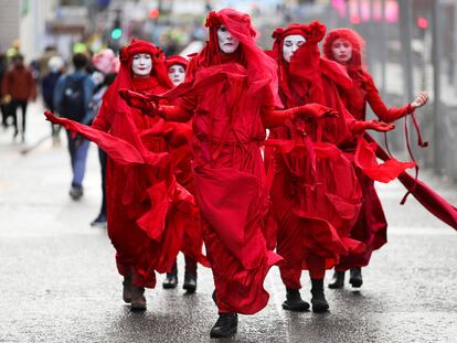 Actvistas del grupo Extinction Rebellion Red Rebel Brigade protestan en Glasgow, este viernes.