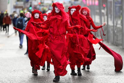 Actvistas del grupo Extinction Rebellion Red Rebel Brigade protestan en Glasgow, este viernes.