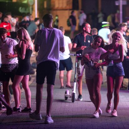 Tourists walk at the resort of Magaluf on the Spanish Balearic island of Mallorca, Spain, Thursday morning, July 16, 2020. Authorities in Spain's Balearic Islands are pulling the plug on endless drunken nights to the beat of techno music by closing bars and nightclubs in beachfront areas popular with young and foreign visitors. (AP Photo/Joan Mateu)