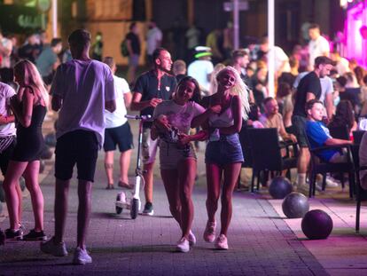 Varios turistas pasean por una zona de copas de Magaluf, en Mallorca.