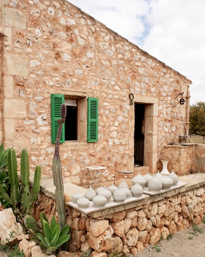 Un lateral de la vivienda que sirve de terraza. Las sillas de hierro las encontraron en la basura y son de los primeros modelos que se produjeron en gran cantidad para los hoteles de la isla en los años sesenta. Sobre el murete, varias piezas de cerámica de Roig.