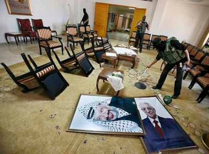 Milicianos de Hamás saquean la sede de la presidencia palestina en Gaza. En el suelo, los retratos de Yasir Arafat y Mahmud Abbas.