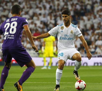 El delantero del Real Madrid Marco Asensio (d) controla el balón junto a Gil Dias, de la Fiorentina.