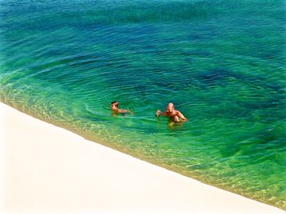 Dos bañistas en una de las picinas naturales de color verde esmerlanda en los Lençóis Maranhenses.