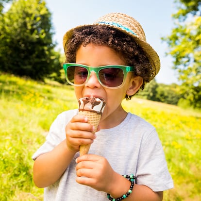 Little boy licking ice cream in a cone during summertime