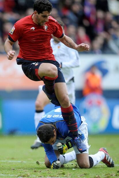 Raúl García salta sobre Diego Alves durante un encuentro frente el Valencia.