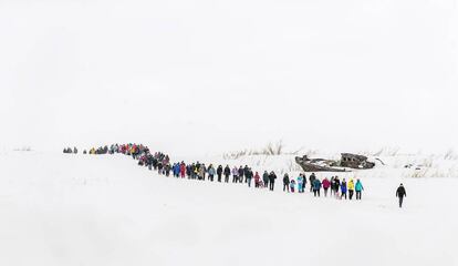 El público de la fiesta de los pastores de renos de Dudinka, caminando  a lo largo de un río cubierto de nieve.