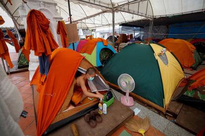 Un joven monje novicio budista sale de su tienda antes de una lección en el instituto educativo monástico Wat Molilokayaram en Bangkok. A pesar de haberse ordenado el cierre de las escuelas en Tailandia como parte de las medidas para luchar contra la covid-19, algunas escuelas monásticas pueden continuar enseñando a sus monjes residentes y novicios bajo estrictas medidas de prevención.