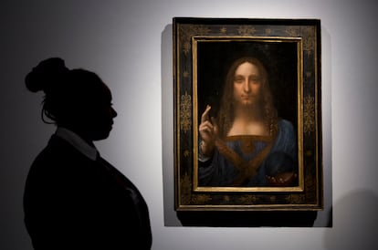 A security guard stands next to the 'Salvator Mundi', attributed to da Vinci, at Christie's auction house.
