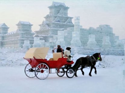 Un carruaje pasa ante un edificio de hielo en la ciudad de Harbin, al noreste de China. 