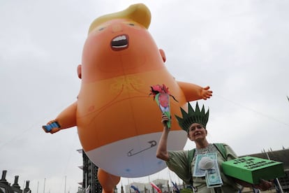 Uma mulher fantasiada de Estátua da Liberdade junto ao 'Baby Trump'