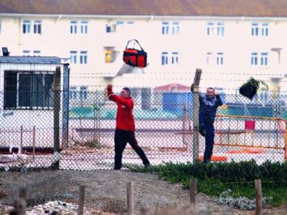 Tres hombres saltan una valla de Gibraltar con bolsas de tabaco.