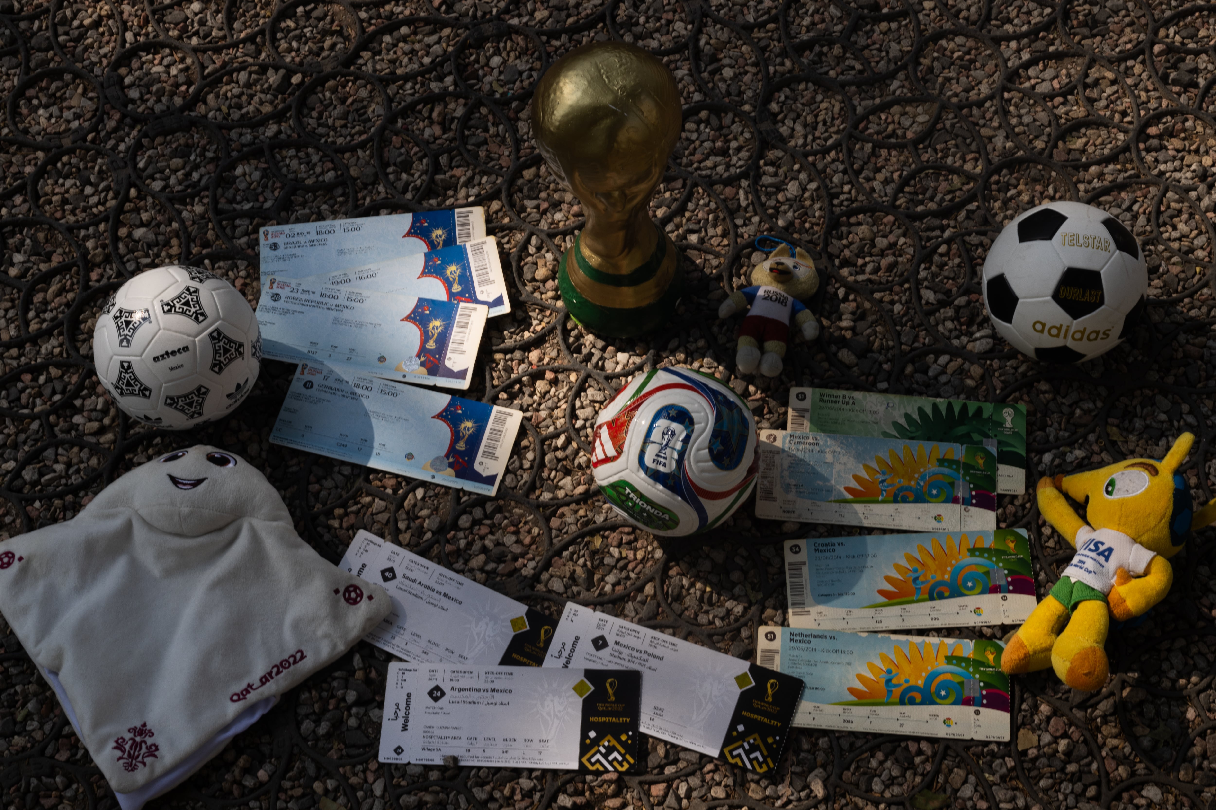 Boletos, balones, copa y mascotas que pertenecen a Carlos Morales, aficionado de la selección mexicana.