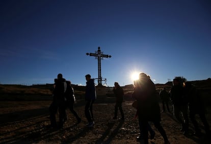 Un grupo de visitantes pasa delante de la Cruz de los caídos, en Belchite viejo.