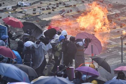 Com o exército chinês está à espreita, os manifestantes obtiveram sucesso simbólico nesta segunda-feira: a proibição de usar máscaras nas manifestações, decidida em outubro pelo governo britânico para tentar desativar a mobilização pró-democracia, foi considerada inconstitucional nesta segunda-feira pelo Tribunal Superior de Hong Kong. Na imagem, os manifestantes se protegem com guarda-chuvas dos canhões de água com os quais a polícia tenta dispersá-los.