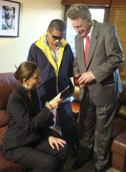 Ingrid Betancourt y el alto comisionado para la Paz, Luis Carlos Restrepo (derecha), comprueban el pasaporte de Isaza (con gafas oscuras).
