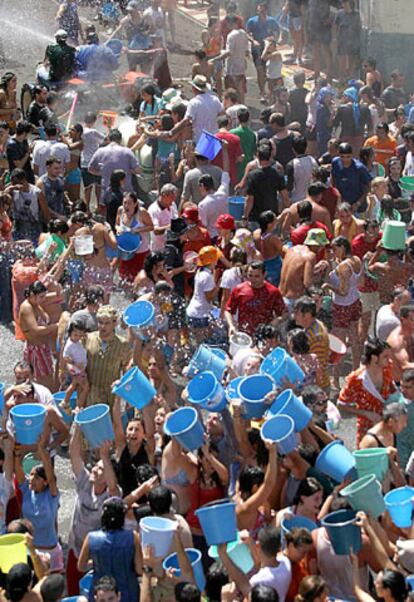 Decenas de jóvenes se tiran cubos de agua durante las fiestas populares de la localidad alicantina de Torremanzanas.