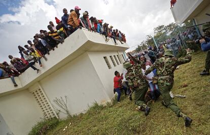 Partidarios del presidente de Kenia Uhuru Kenyatta participan en enfrentamientos con la policía durante su ceremonia de inauguración después de tratar de atravesar las puertas para entrar y ser bombardeados con gas lacrimógeno.