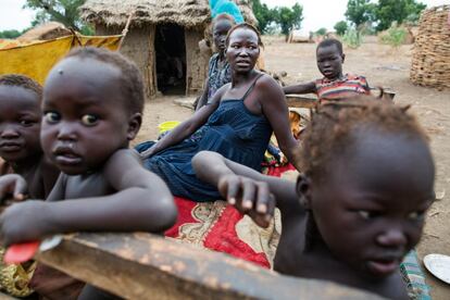 Tathilia Butrus, embarazada de siete meses y madre de cinco hijos, descansa rodeada de algunos de ellos fuera de su cabaña en Dangaji. Se pueden contar por docenas la mujeres del pueblo que, pese a su estado avanzado de gestación, ponen en riesgo sus vidas asumiendo tareas muy duras que nadie hace por ellas.