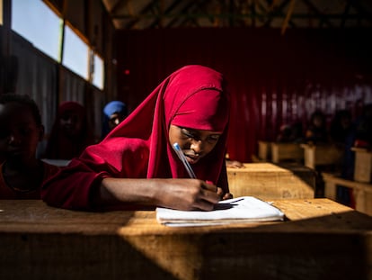 Una niña trabaja en una clase de la escuela montada en el campamento para desplazados internos de Kaxaarey, en Dolow, Somalia.