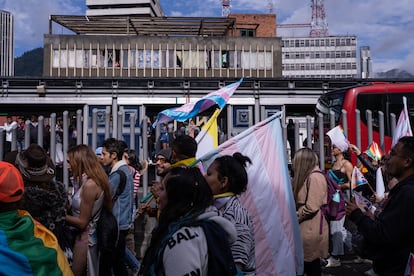 Personas observan pasar la marcha de 'Yo Marcho Trans' desde una estación de Transmilenio en Bogotá, el 7 de julio de 2023.