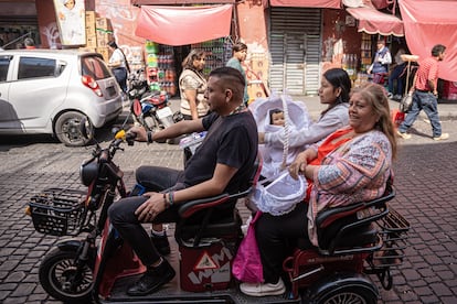 Una familia porta una canasta con un niño Dios.