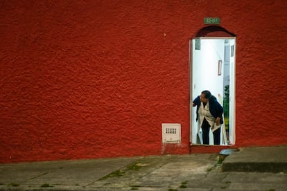 Una mujer observa desde la puerta de su casa la guerra de voladores (plvora) en la calle principal del barrio.