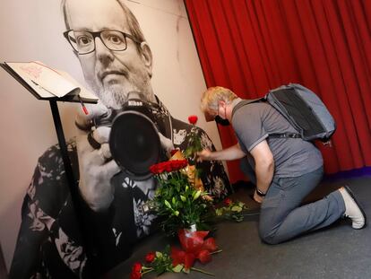 El director de la revista 'Enderrocs' coloca unas flores delante de la fotografía del fotógrafo fallecido este lunes Xavier Mercadé, en la exposición que le decida el Palau Robert, que se prorroga.