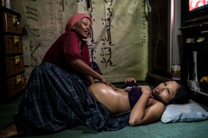 Mak Muji palpa a su vecina, que se encuentra en el séptimo mes de embarazo, para comprobar si el feto está vivo y si se ha colocado en la posición correcta para el parto. 
