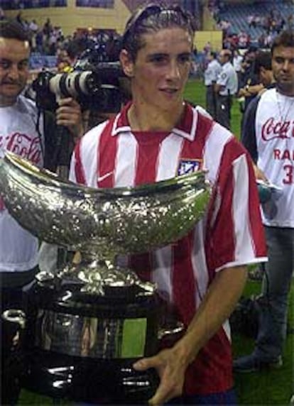 Torres sostiene el trofeo Villa de Madrid.