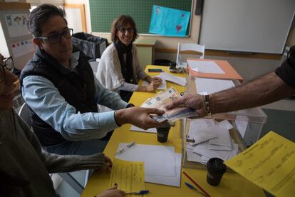 Election officials are paid for their work at a polling station in a school in the San Agustín neighborhood in Madrid.