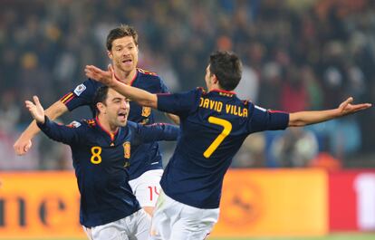 David Villa celebra el gol con Xavi y Xabi Alonso.