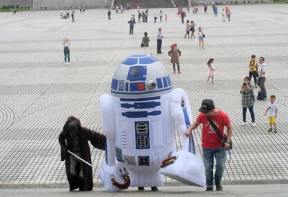 Dos jóvenes suben un muñeco hinchable del personaje de ficción R2-D2 en Taipéi (Taiwán).