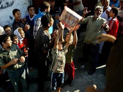 Habitantes del campo de refugiados de Yabalia reciben alimentos lanzados desde un camión de la ONU.