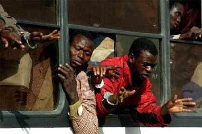 Inmigrantes esposados piden ayuda en Bouarfa desde los autobuses en que son trasladados por la policía marroquí con destino desconocido.