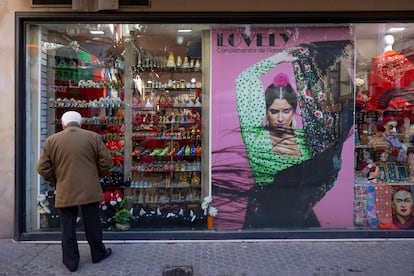 Un hombre mayor mira un escaparate en el centro de Sevilla.