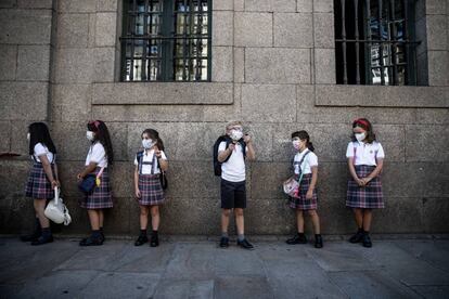 Alumnos del colegio concertado de la Compañía de María en Santiago de Compostela (A Coruña), esperan para acceder al centro en el primer día de colegio.