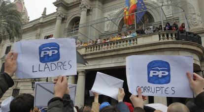 Asistentes a la 'mascletà' exhiben sobres contra el PP.