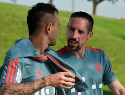 Ribery (D) habla con Rafinha en el entrenamiento de este domingo.  